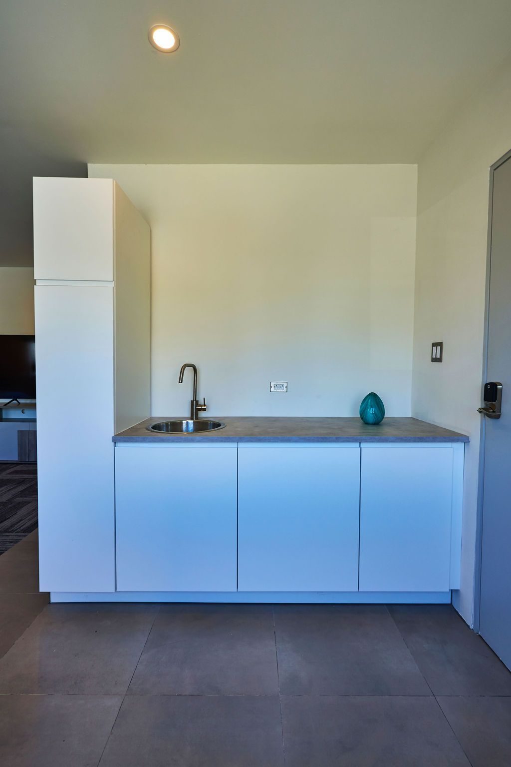 Suite kitchenette at Ola Boutique Hotel with white cabinets, a counter and a sink